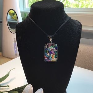 Artisan made glass and sterling silver pendant.